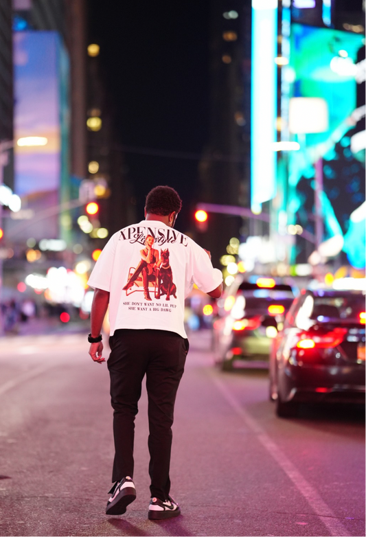 Person walking on a city street at night with bright lights and neon signs.